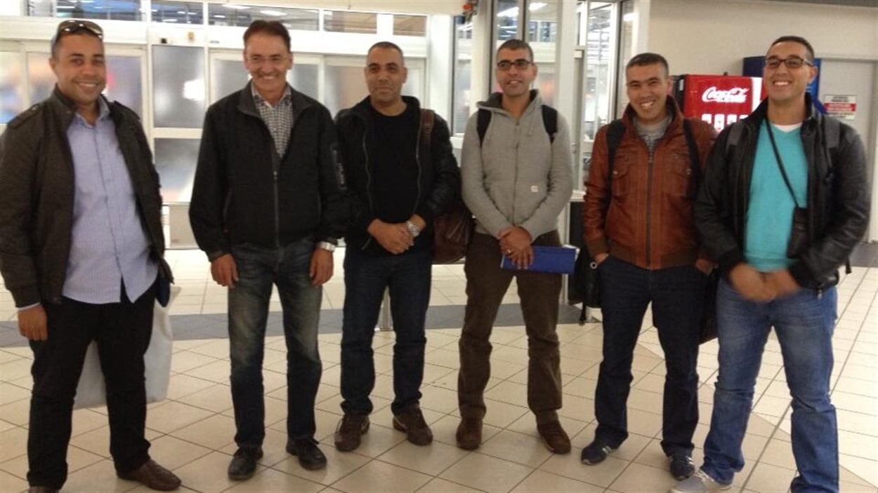 Le dirigeant de l'agence de placement Prud'homme International, Denis Prud'homme (deuxième à gauche), accueille cinq travailleurs étrangers temporaires francophones du Maroc, le 19 septembre 2013 à l'aéroport de Saskatoon.