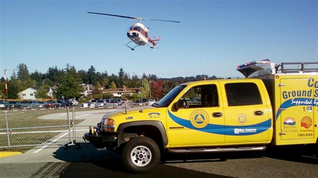 Un hélicoptère se pose près d'un camion de l'équipe de recherche et de sauvetage de la vallée Comox.