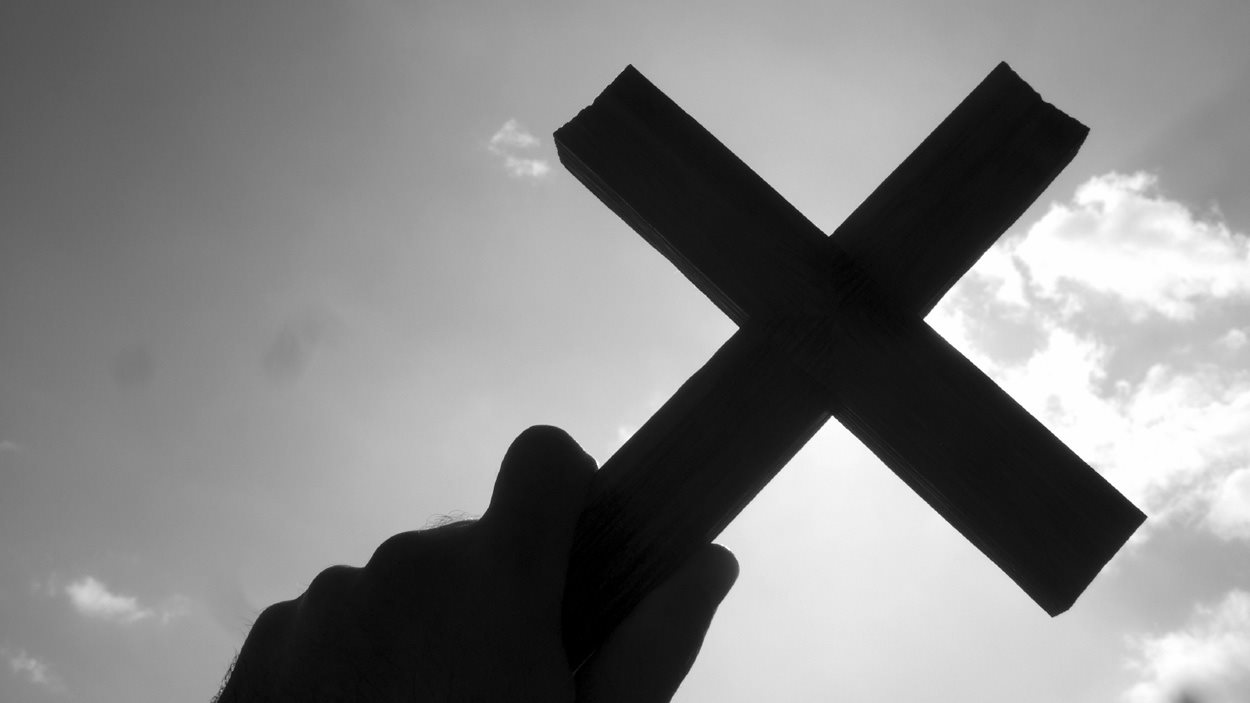 Une main qui brandit une croix