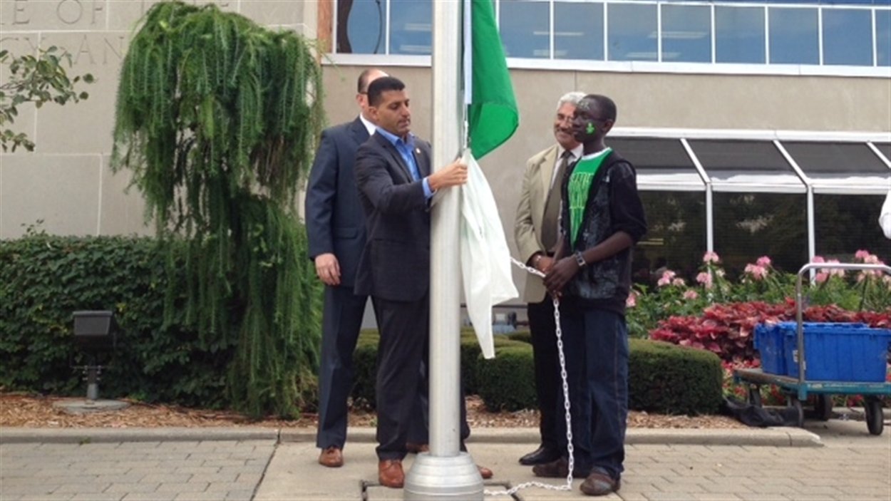 Le maire de Windsor, Eddie Francis, hisse le drapeau franco-ontarien devant l'hôtel de ville.
