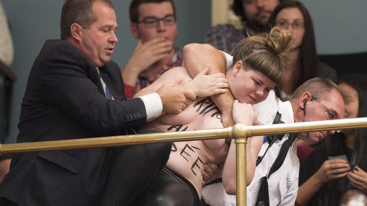 Une manifestante agrippée par des agents de sécurité à l'Assemblée nationale, le 1er octobre