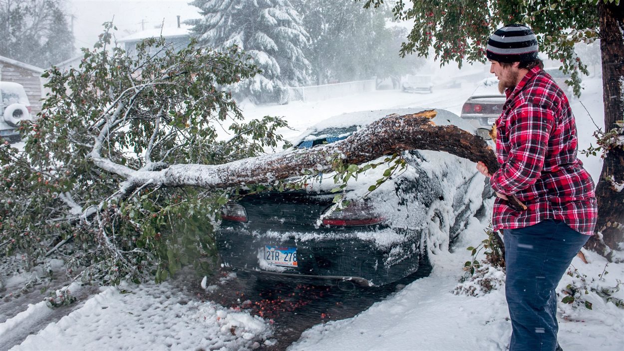 Un homme tente de nettoyer les dommages causés par une importante tempête hivernale, au Dakota du Sud