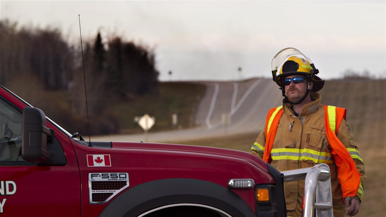 Des pompiers tentent de maîtriser le feu survenu après le déraillement d'un train près de Gainford, en Alberta.