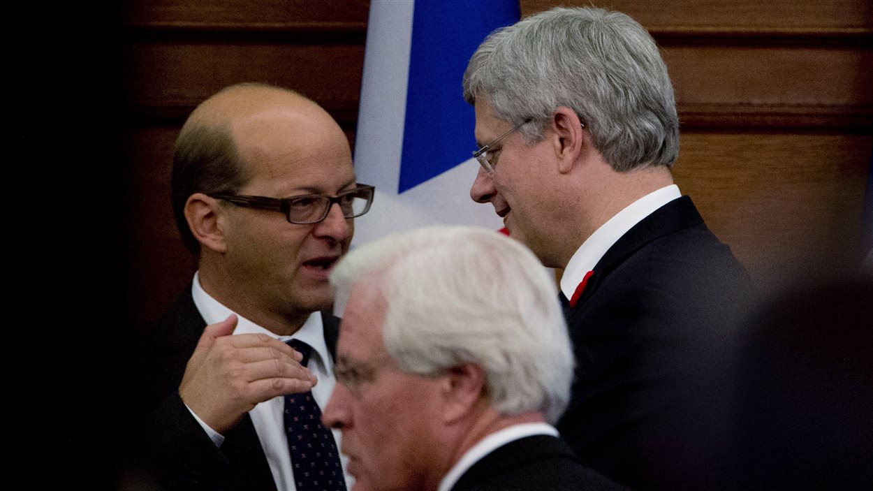 Le leader du gouvernement au Sénat, Claude Carignan, s'entretient avec le premier ministre Harper après un caucus à Ottawa.