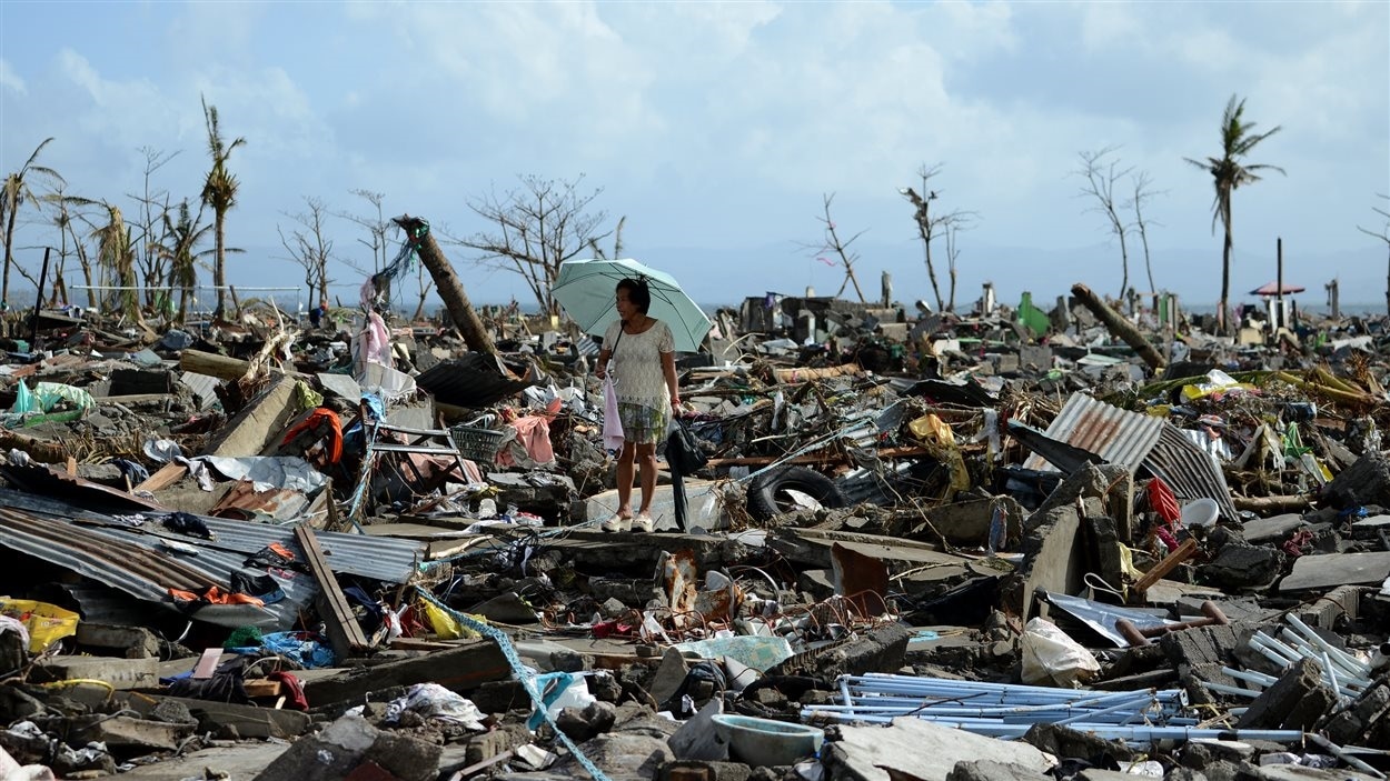Une femme marche dans un champ de débris laissés par le passage du typhon Haiyan aux Philippines.