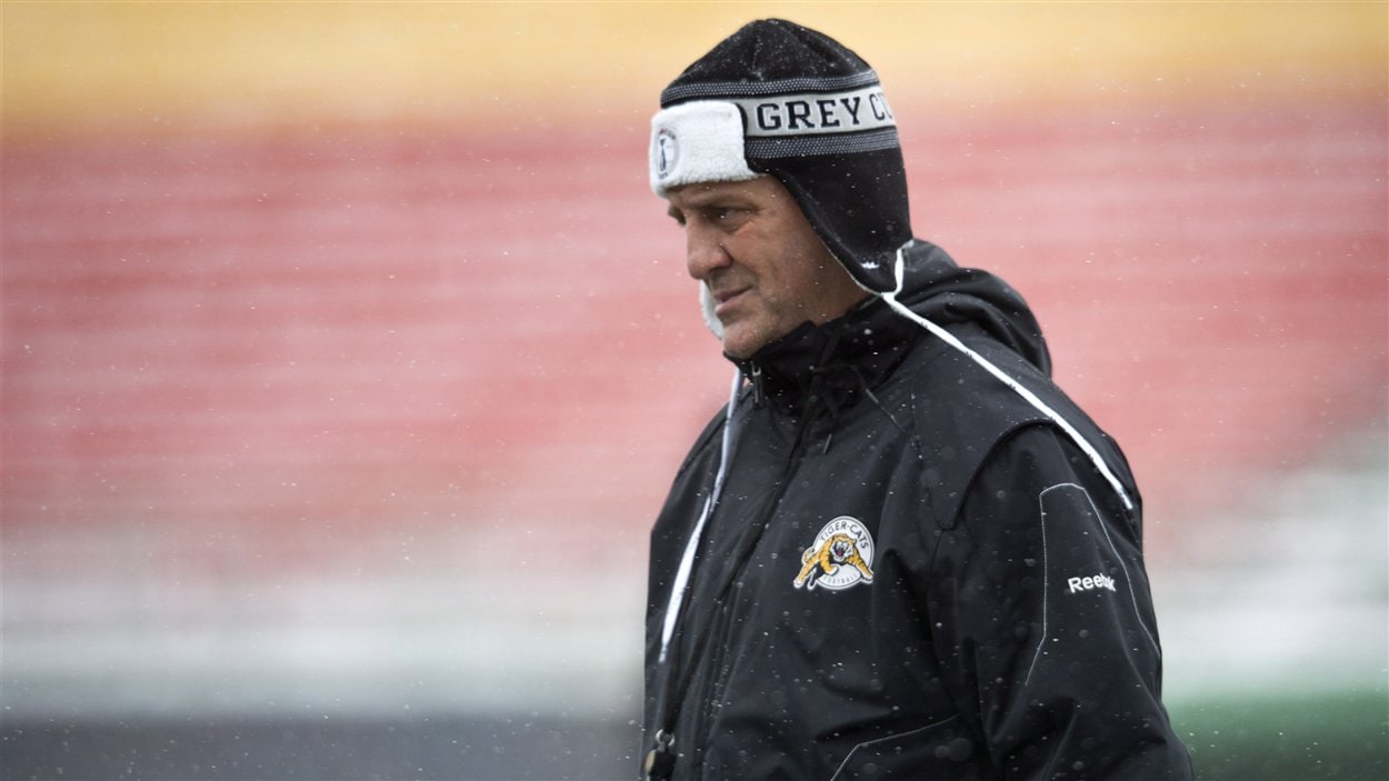 L'entraîneur-chef des Tiger-Cats, Kent Austin, supervise ses joueurs à l'entraînement, au froid, à Regina.