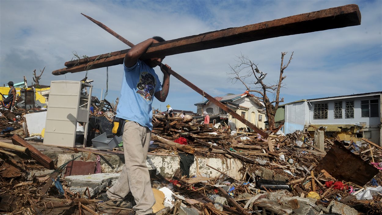 Un survivant transporte des débris à Tacloban.
