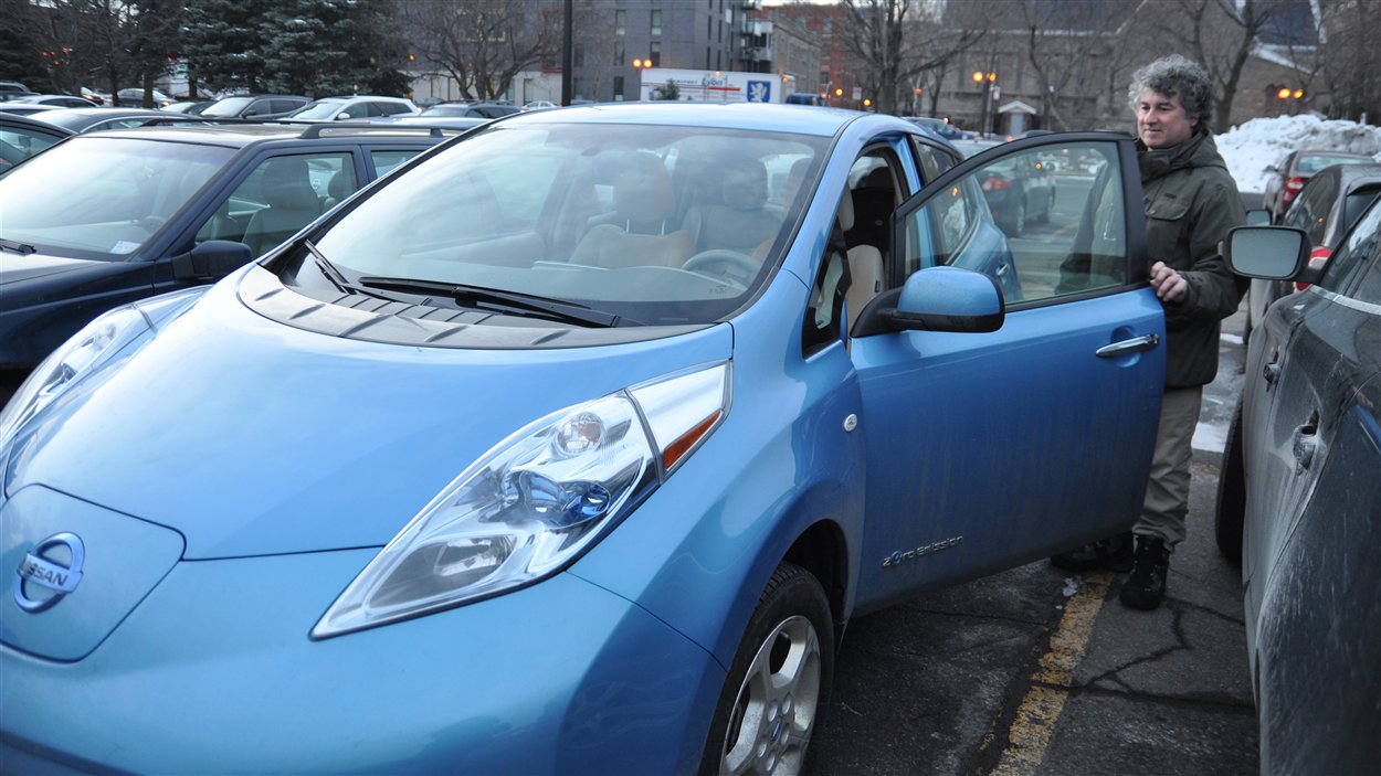 Alain Collin monte à bord de sa voiture électrique, une Nissan Leaf