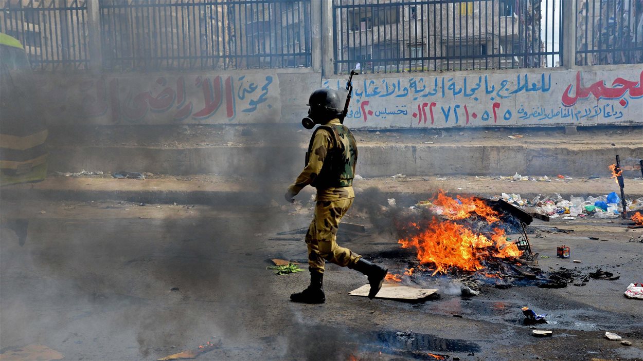 Un soldat égyptien marche dans les débris à la suite d'une manifestation des Frères musulmans dans la ville d'Alexandrie.