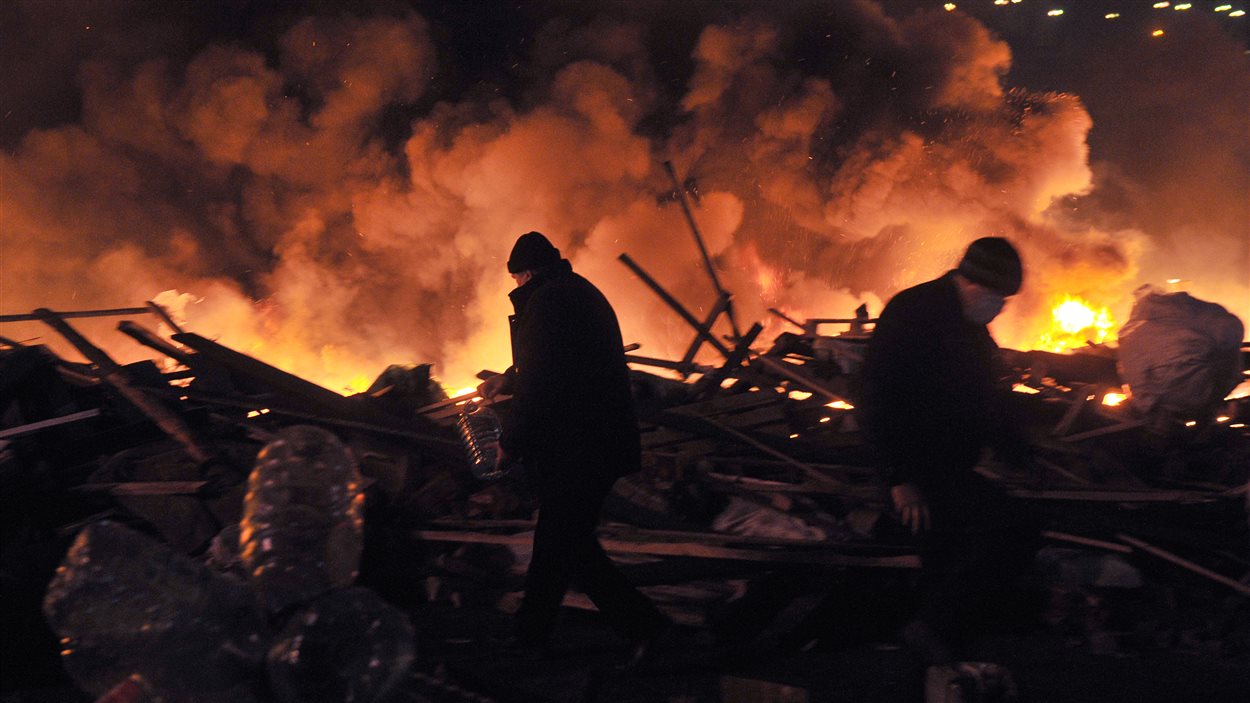Cartons, panneaux de bois, tentes : un rideau de flammes a tenu provisoirement les policiers à distance.