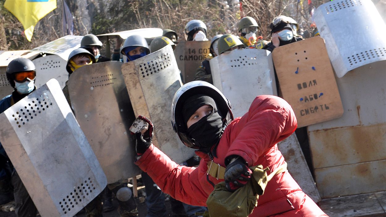 Un manifestant se prépare à lancer une brique lors d'affrontements avec la police à Kiev.