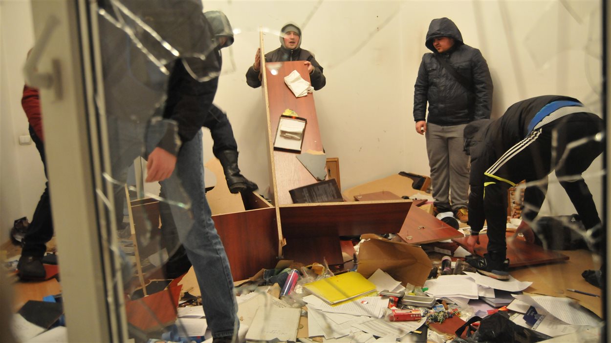 Des manifestants fouillent les décombres d'un poste de police de Lviv.