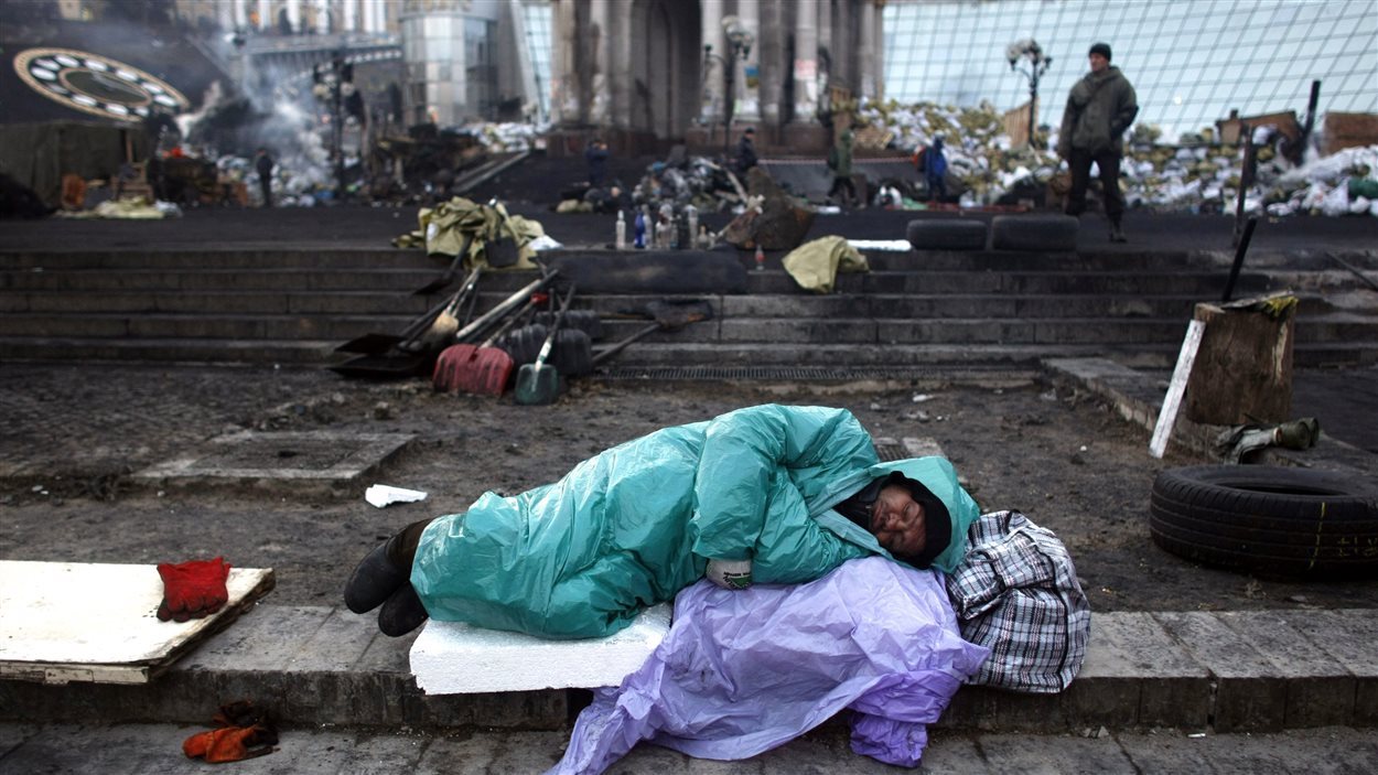 Un manifestant dort au milieu des décombres sur la place de l'Indépendance.