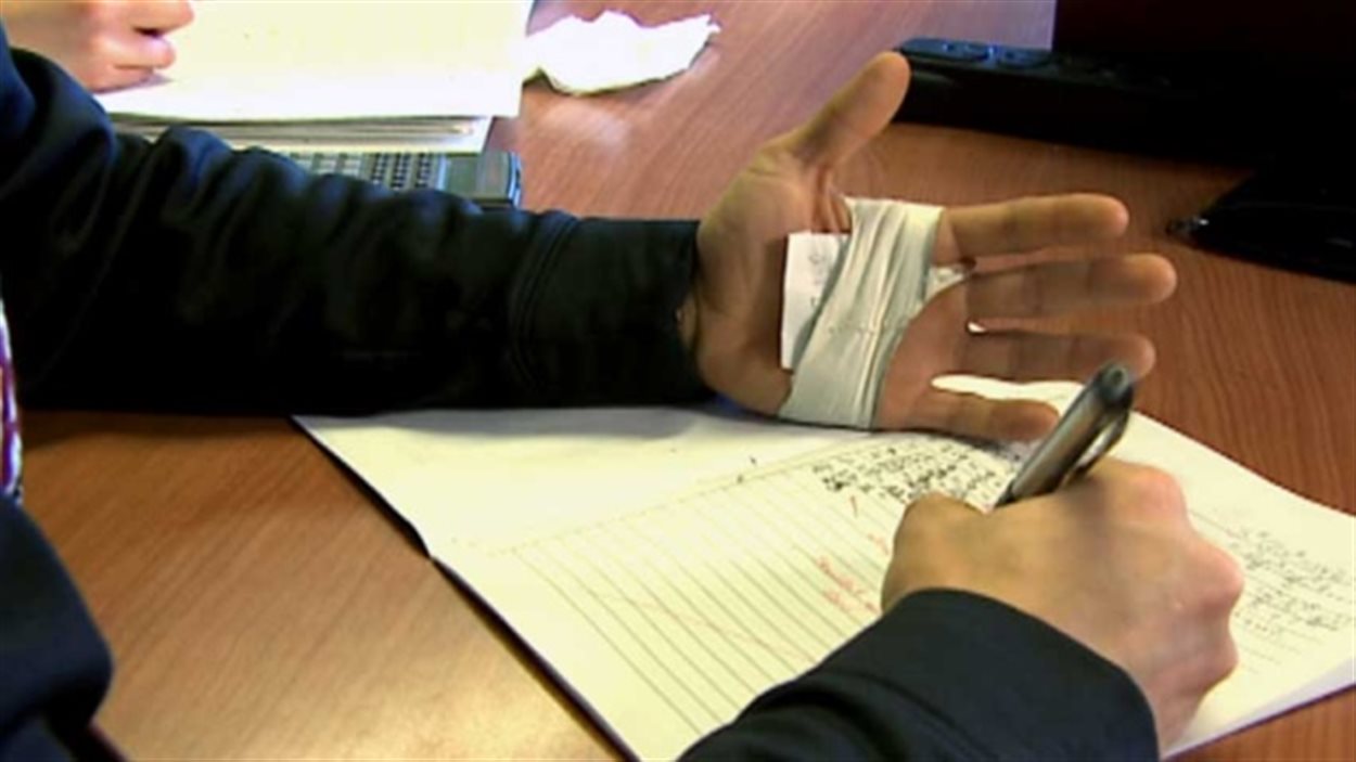 Un étudiant triche à un examen en dissimulant des notes dans sa main.
