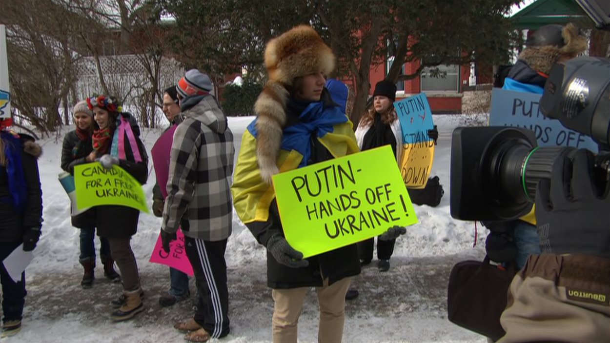 Une manifestante devant l'ambassade de Russie à Ottawa.