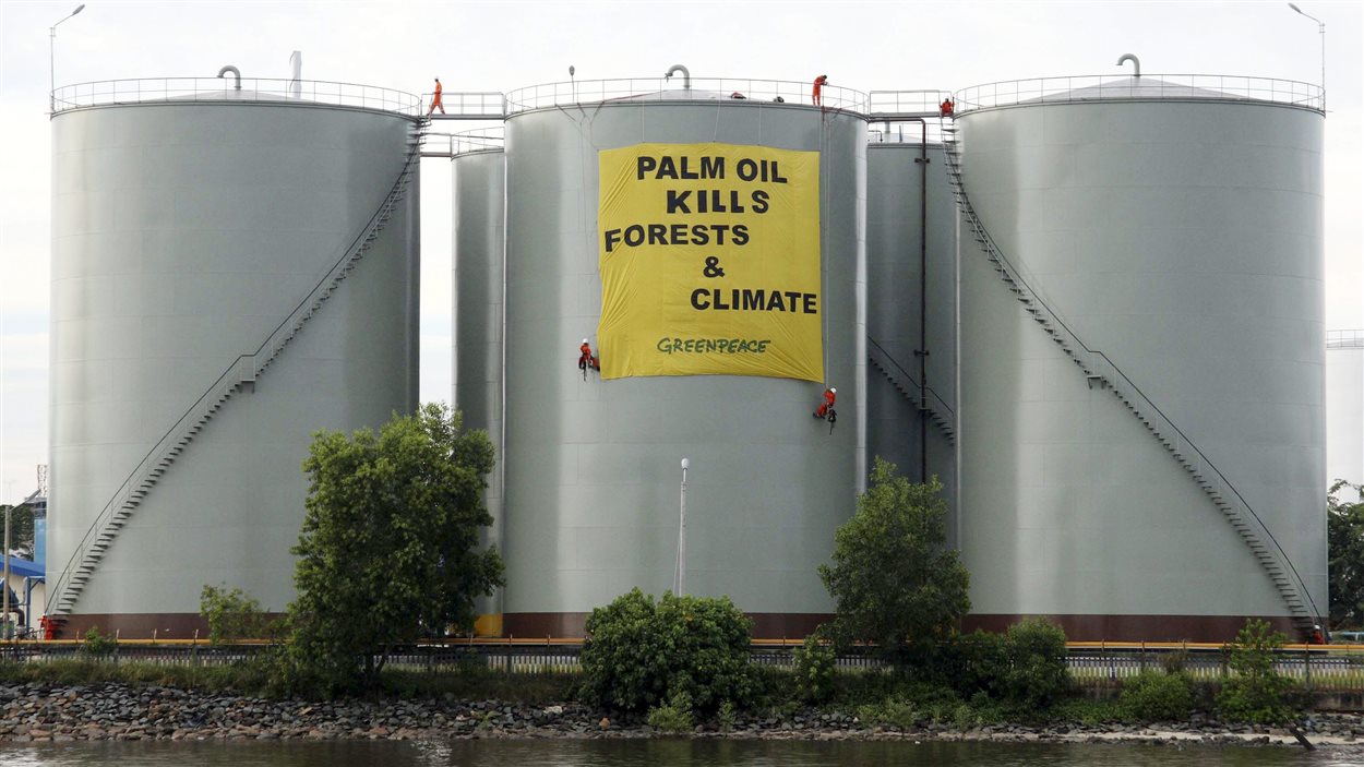 En Indonésie, en 2007, une bannière est déployée par Greenpeace sur des réservoirs d'huile de palme.