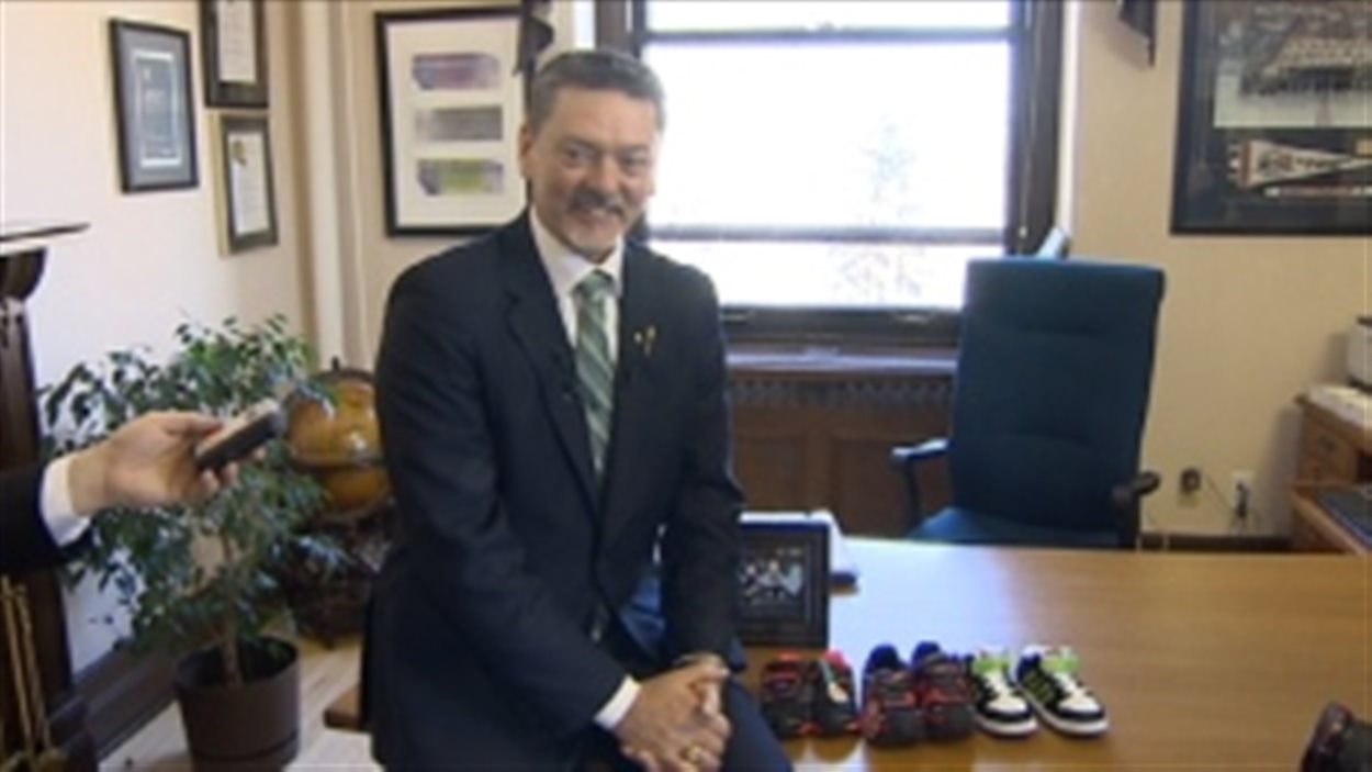 Le ministre des Finances Doug Horner avec les chaussures qu'il montre à la veille du dépôt de son budget 2014-2015