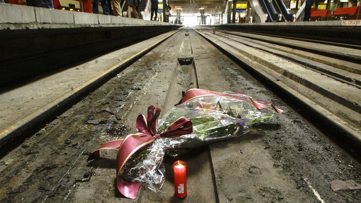 Bouquet de fleurs et chandelles sur un rail de la gare d'Atocha, à Madrid