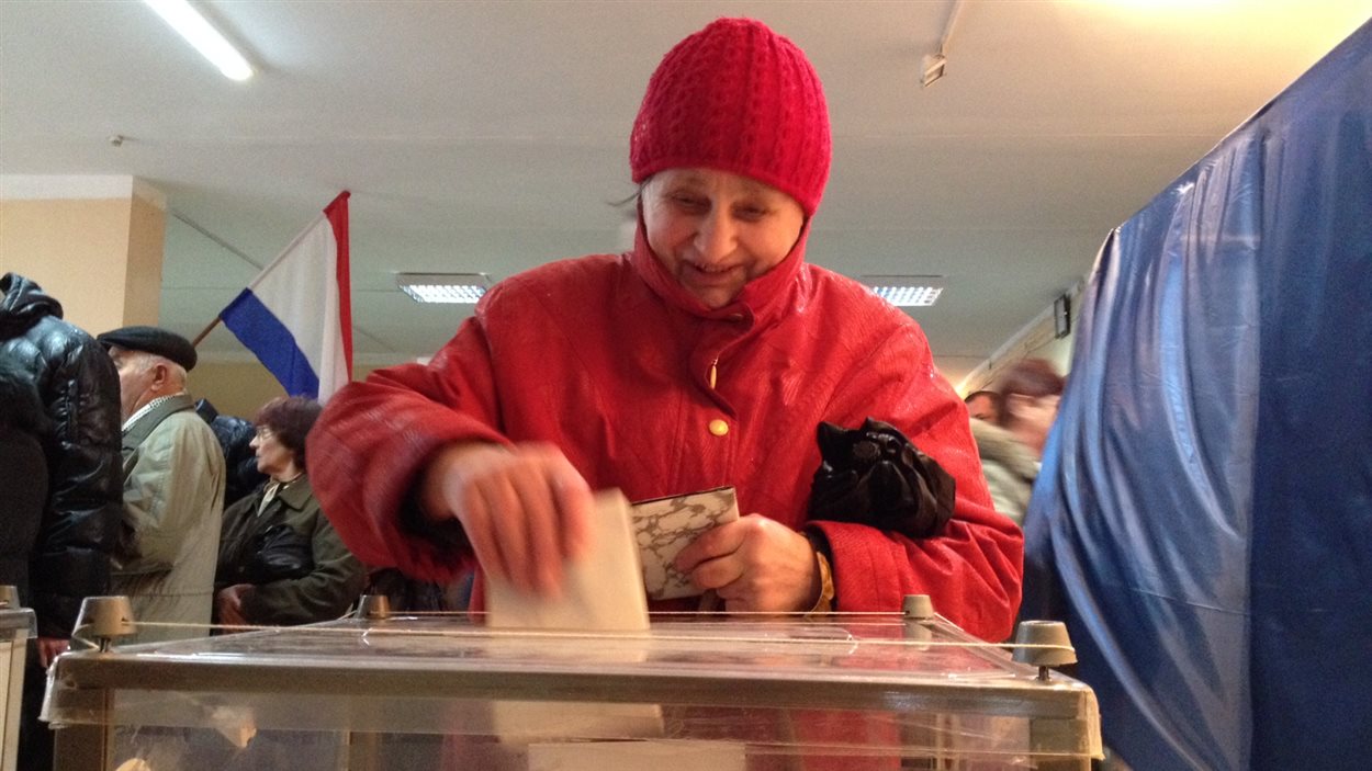 Une dame dépose son vote sur le rattachement de la Crimée à la Russie, le 16 mars 2014