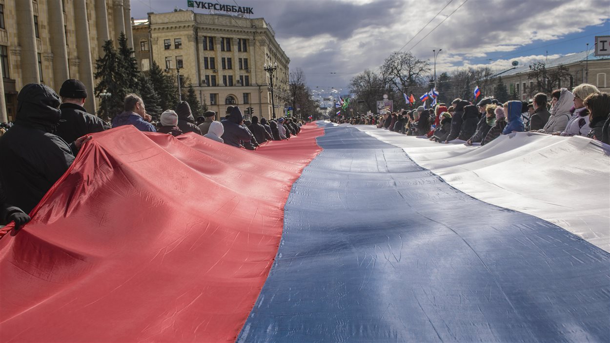Des manifestants prorusses portant un drapeau géant à Kharkiv, en Ukraine, le 16 mars 2014