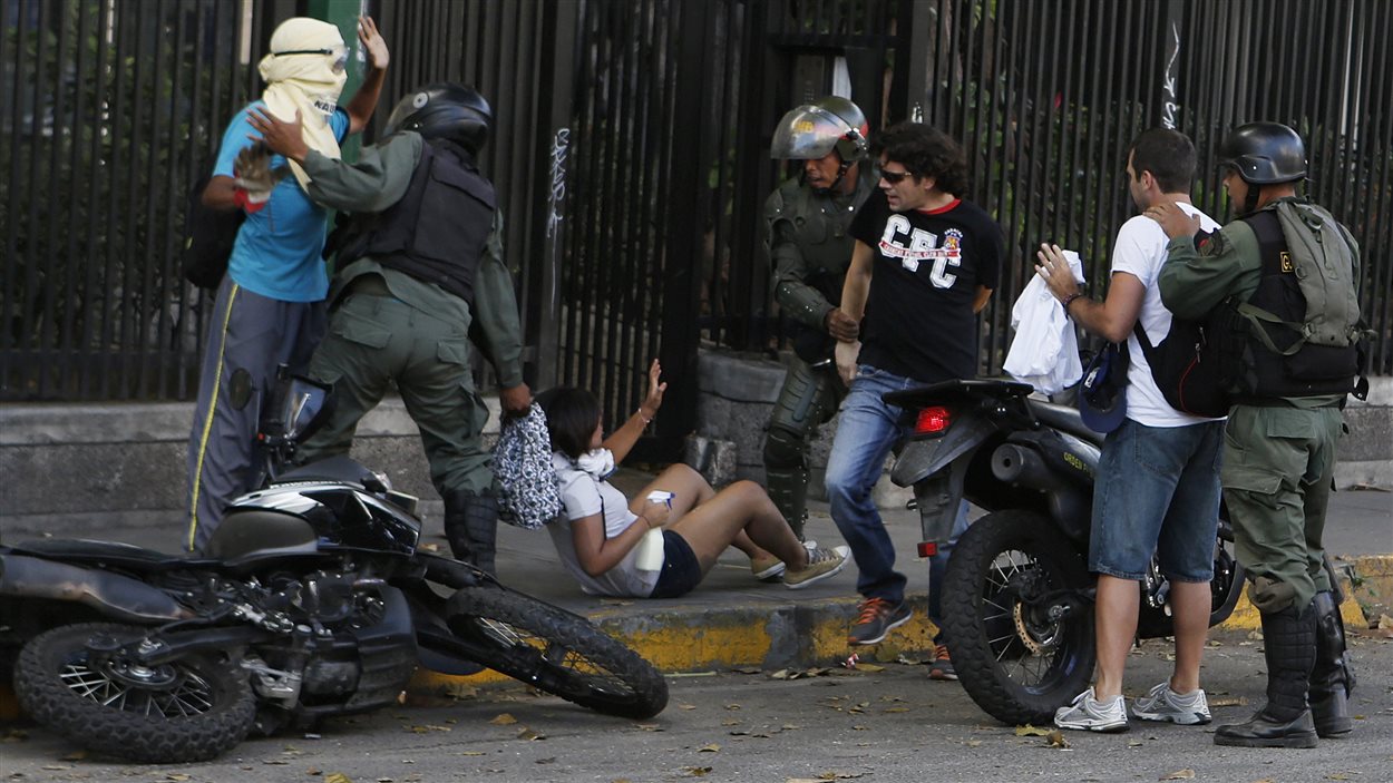 Des membres de la Garde nationale du Vénézuéla arrêtent des manifestants qui soutiennent l'opposition, lundi à Caracas.