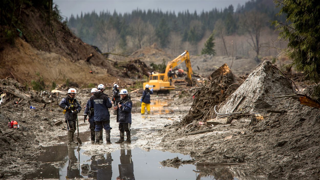 Les sauveteurs ont continué leurs recherches, samedi, dans la boue et les débris laissés par le glissement de terrain, le long de la route 530 près de Darrington.