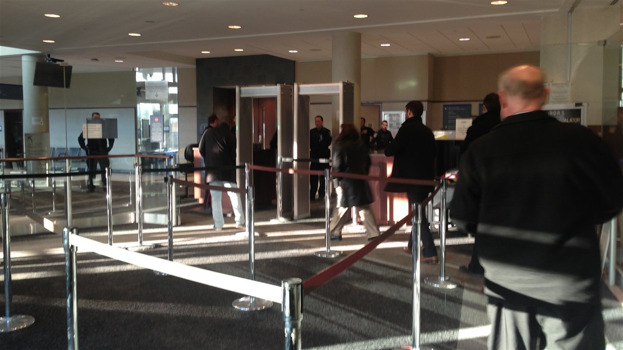 Des gens font la file avant de passer au détecteur de métal lundi matin au palais de justice de Brampton.