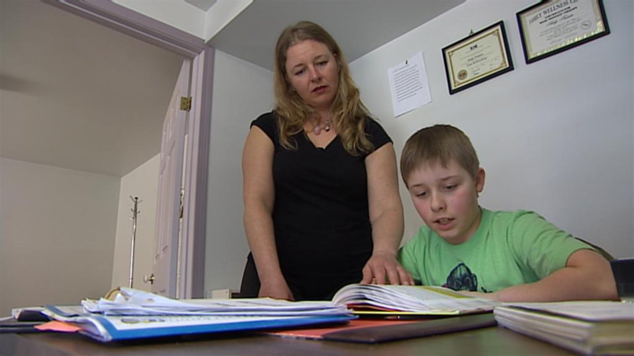 Kim Baul aide son fils, Aidan Walsh, avec ses devoirs, depuis qu'il est suspendu de son école, car il n'est pas vacciné contre la rougeole.