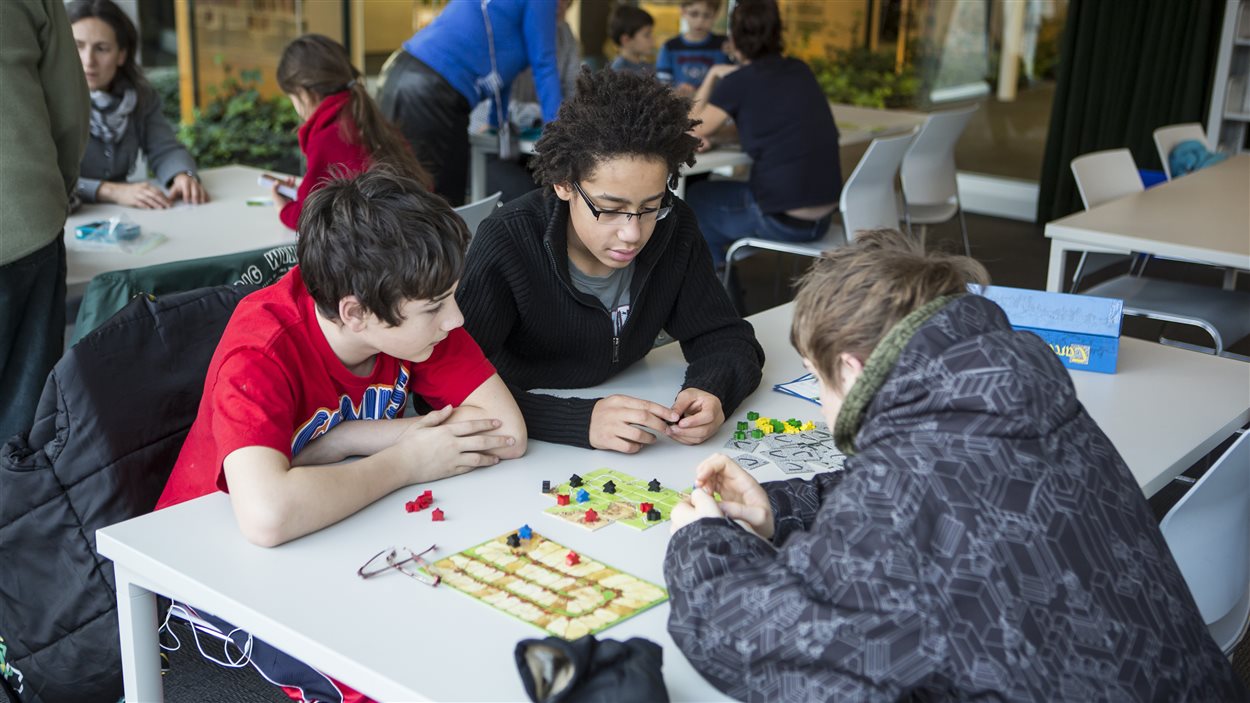 Des jeunes participant à une séance de jeux de société dans une bibliothèque de Montréal.