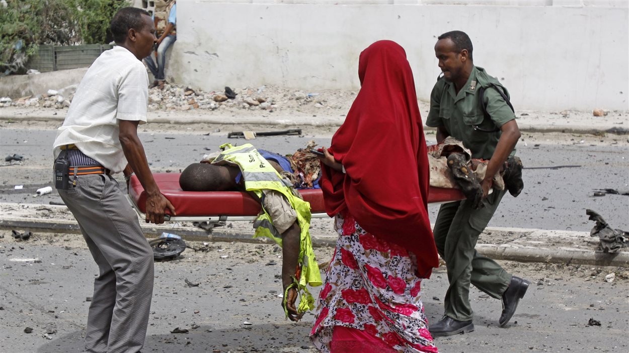 Des soldats transportent un policier blessé lors de l'attentat à Mogadiscio, le 24 mai.