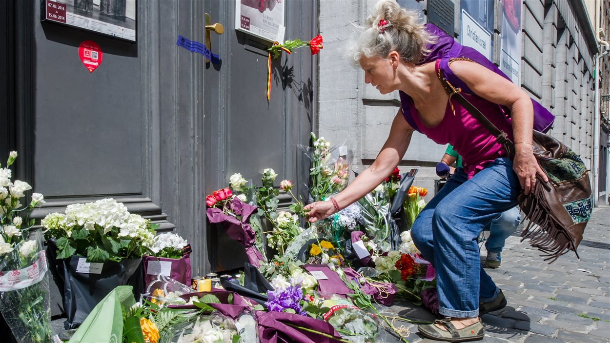 Une femme dépose des fleurs devant le Musée juif de Bruxelles, au lendemain de la fusillade.