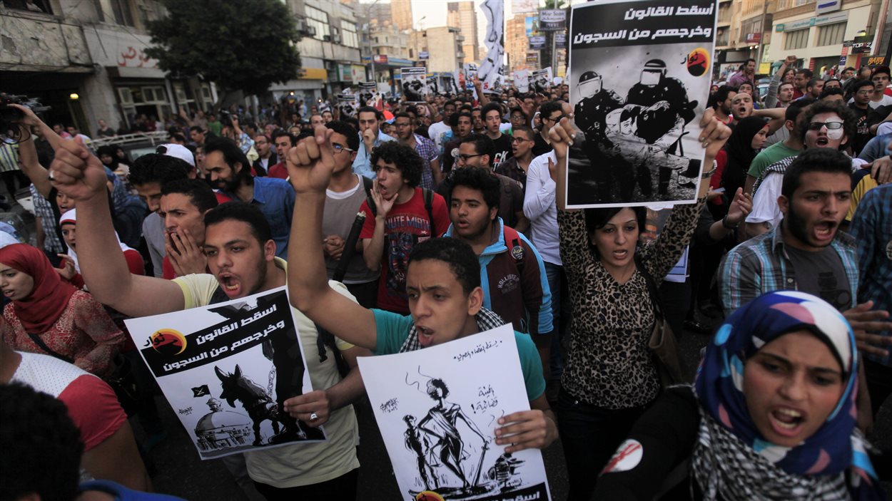 Des membres du Mouvement des jeunes du 6 avril protestent contre une loi imposant des limites aux manifestations et contre des décisions judiciaires défavorables aux opposants politiques, en face du palais présidentiel, au Caire, le 26 avril 2014.