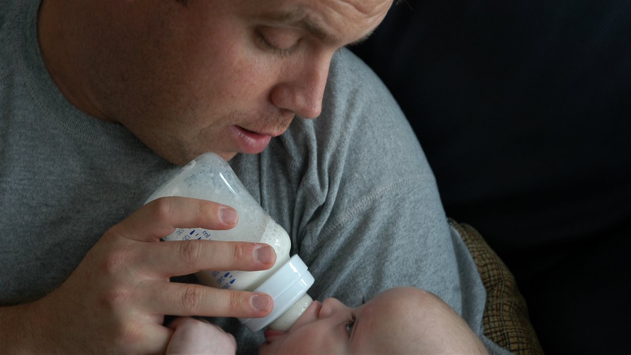 Un homme nourrit un bébé au biberon
