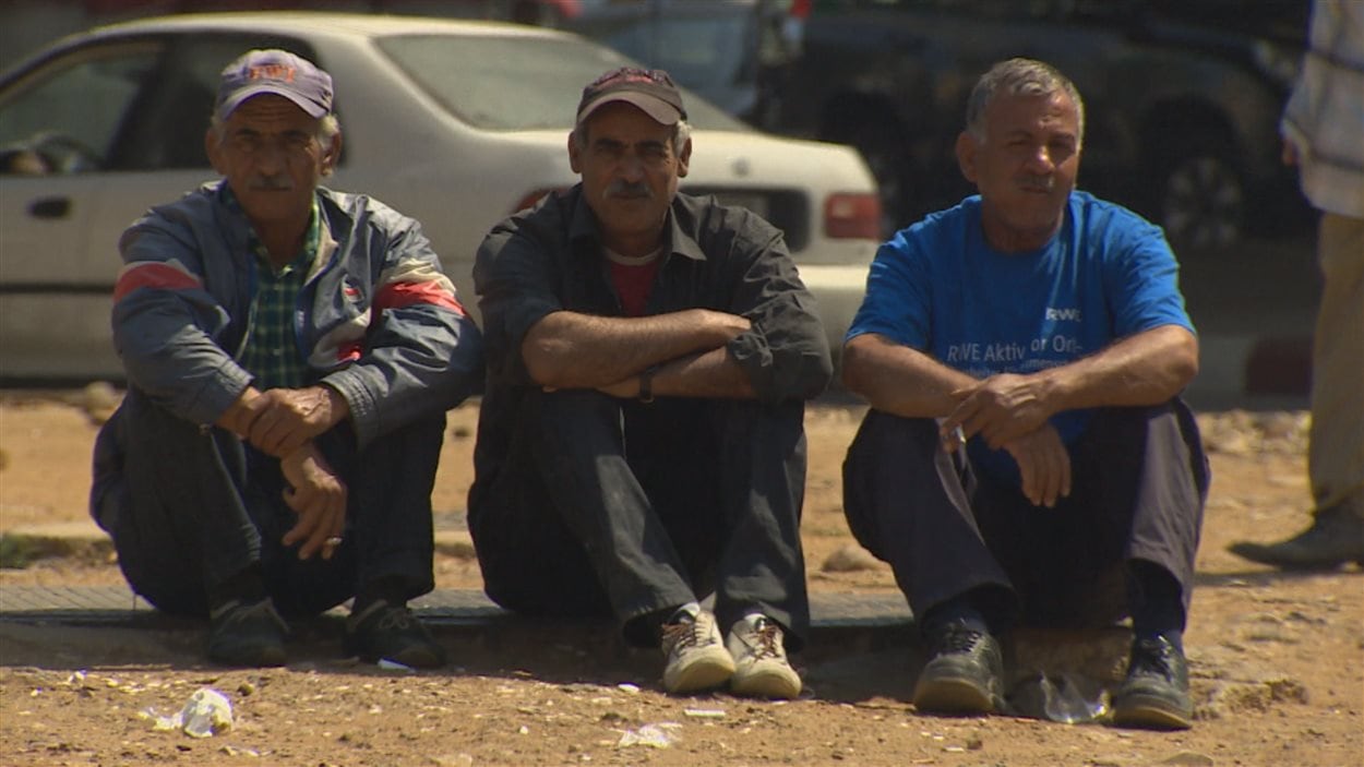 Trois Syriens attendant du travail dans le quartier libanais de Bourj Hammoud