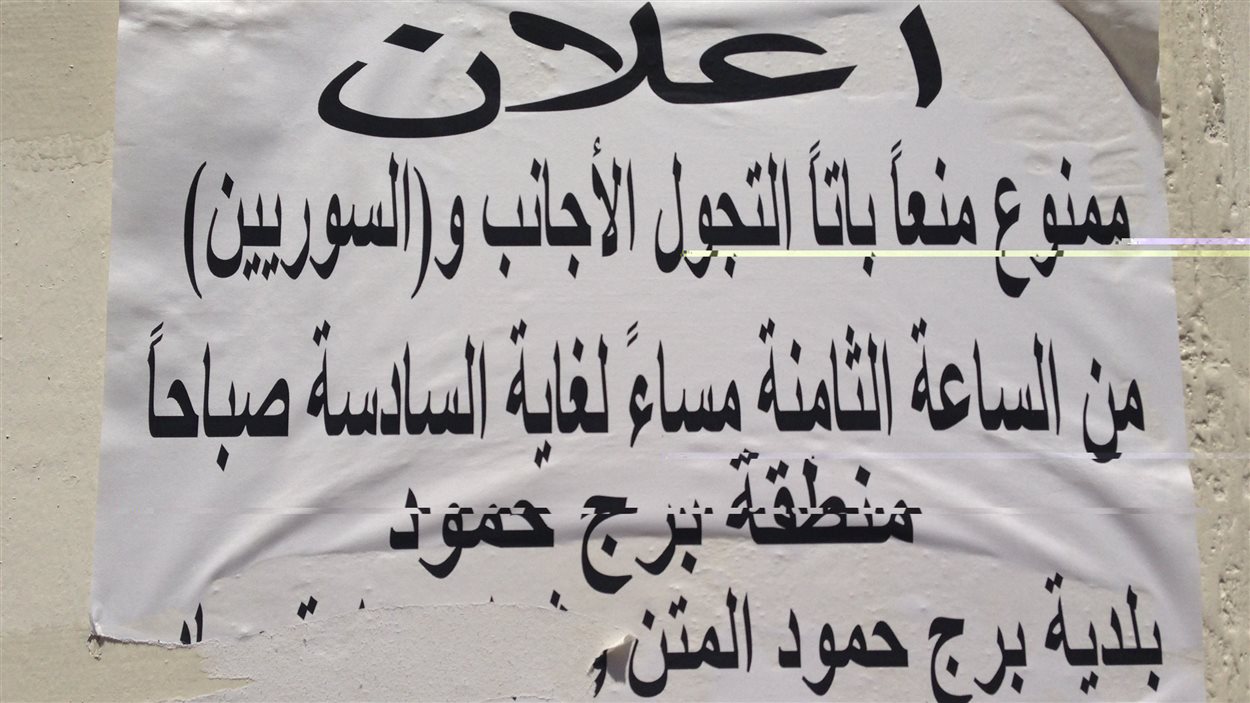 Sur l'affiche, on peut lire : « Il est interdit à tout étranger - entre parenthèse les Syriens - de circuler entre 20 h et 6 h par ordre de la municipalité. »