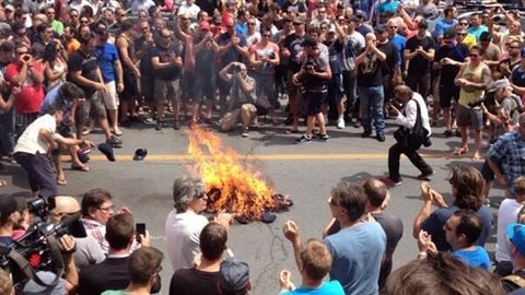 Les syndiqués brûlent leur casquette devant l'hôtel de ville de Montréal.