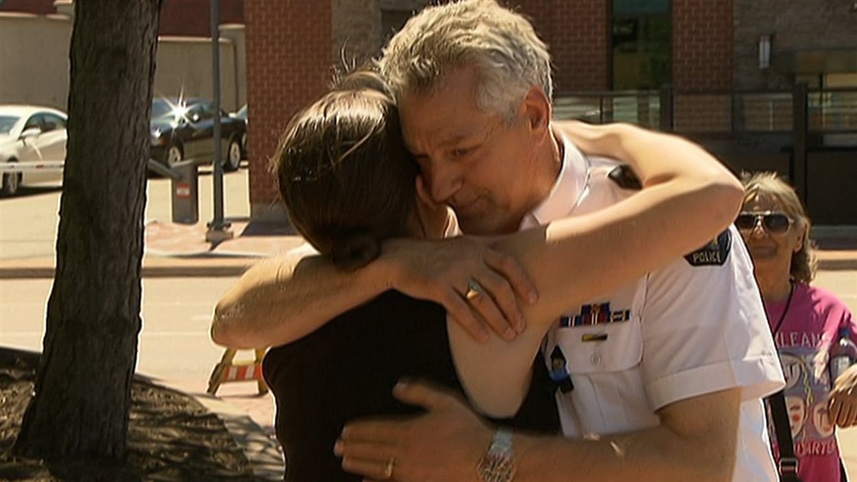 Un policier de la GRC reçoit une accolade d'une résidente de Moncton.