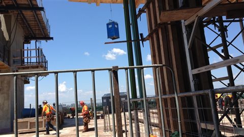 1500 ouvriers travaillent en ce moment sur le chantier. Une telle construction au centre-ville nécessite toute une logistique. Les toilettes, notamment, sont montées sur les étages par des grues.