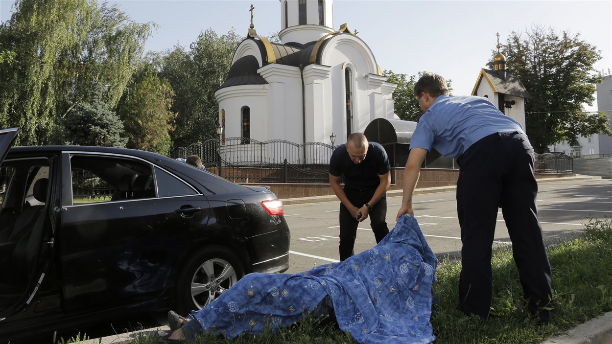 Les enquêteurs examinent la dépouille d’un policier tué durant une attaque des forces pro-russes à Donetsk, mardi.