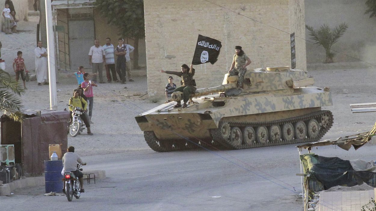 Des insurgés sunnites défilent dans les rues d'une ville de Syrie.