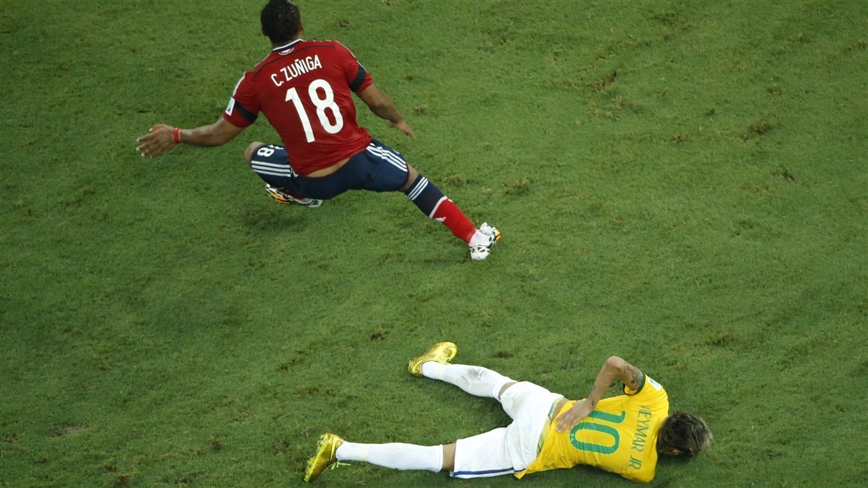 Juan Camilo Zuniga tourne le dos à Neymar, étendu au sol.
