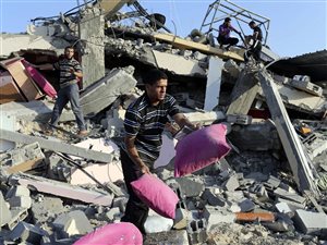 Un résident de Rafah tente de récupérer des effets personnels dans les restes de sa demeure.