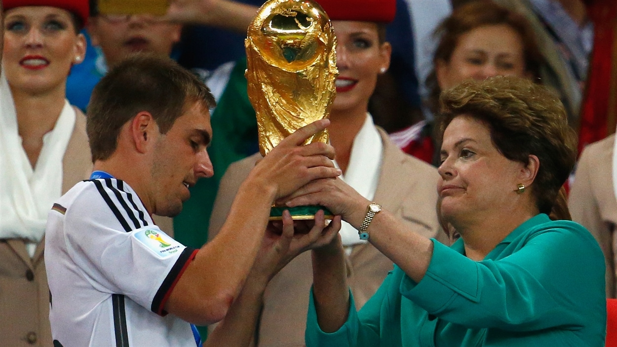 Philipp Lahm reçoit le trophée de la Coupe du monde des mains de la présidente brésilienne Dilma Rousseff.