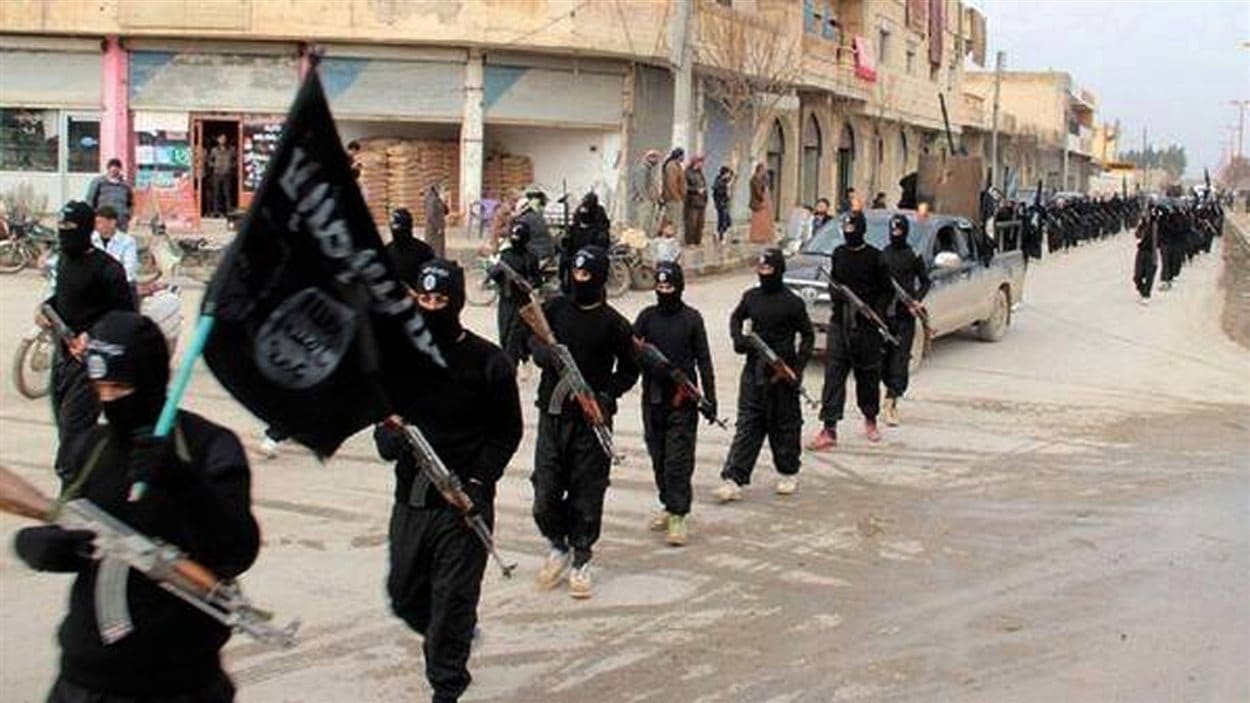 Des militants de l’organisation armée djihadiste l'État islamique marchent à Raqqa, en Syrie