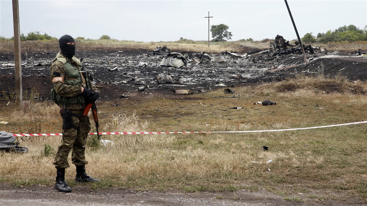 Un rebelle prorusse surveille les débris de l'avion écrasé en Ukraine, le 19 juillet 2014
