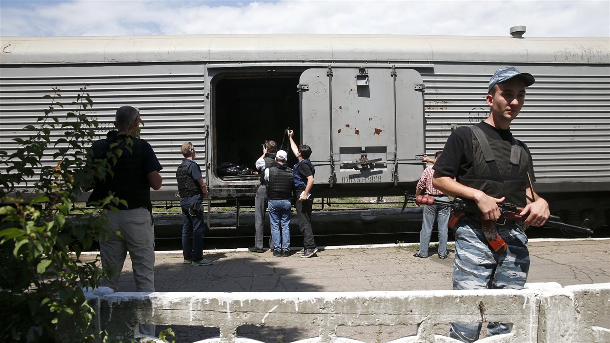 Des observateurs de l'OSCE inspectent un train où ont été transporté 169 corps des victimes de l'écrasement. 