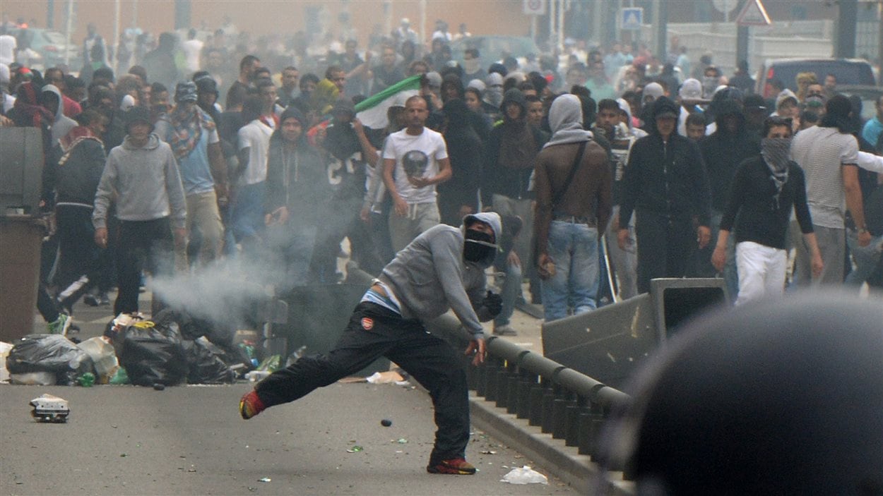 Des manifestants lancent des projectiles aux policiers qui tentent de contenir la manifestation pro-palestinienne à Sarcelles, quartier de Paris. 