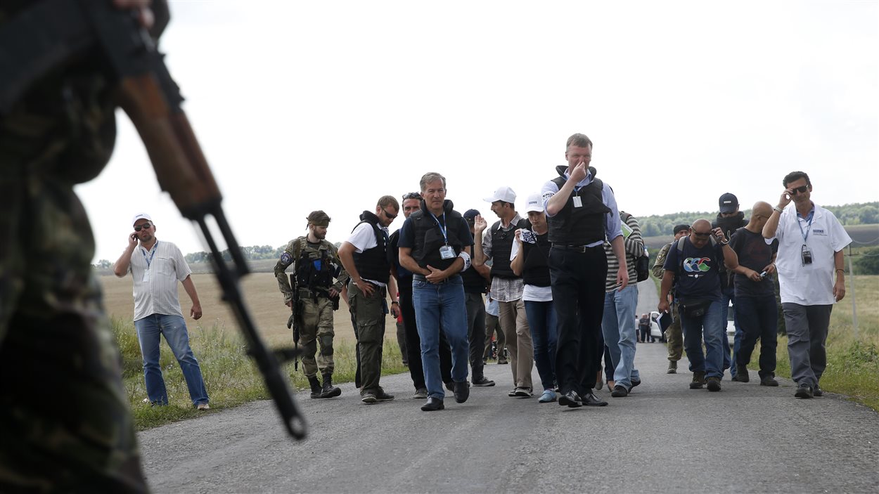 Des rebelles prorusses accompagnent les enquêteurs sur le site de l'écrasemenet de l'avion malaisien. 