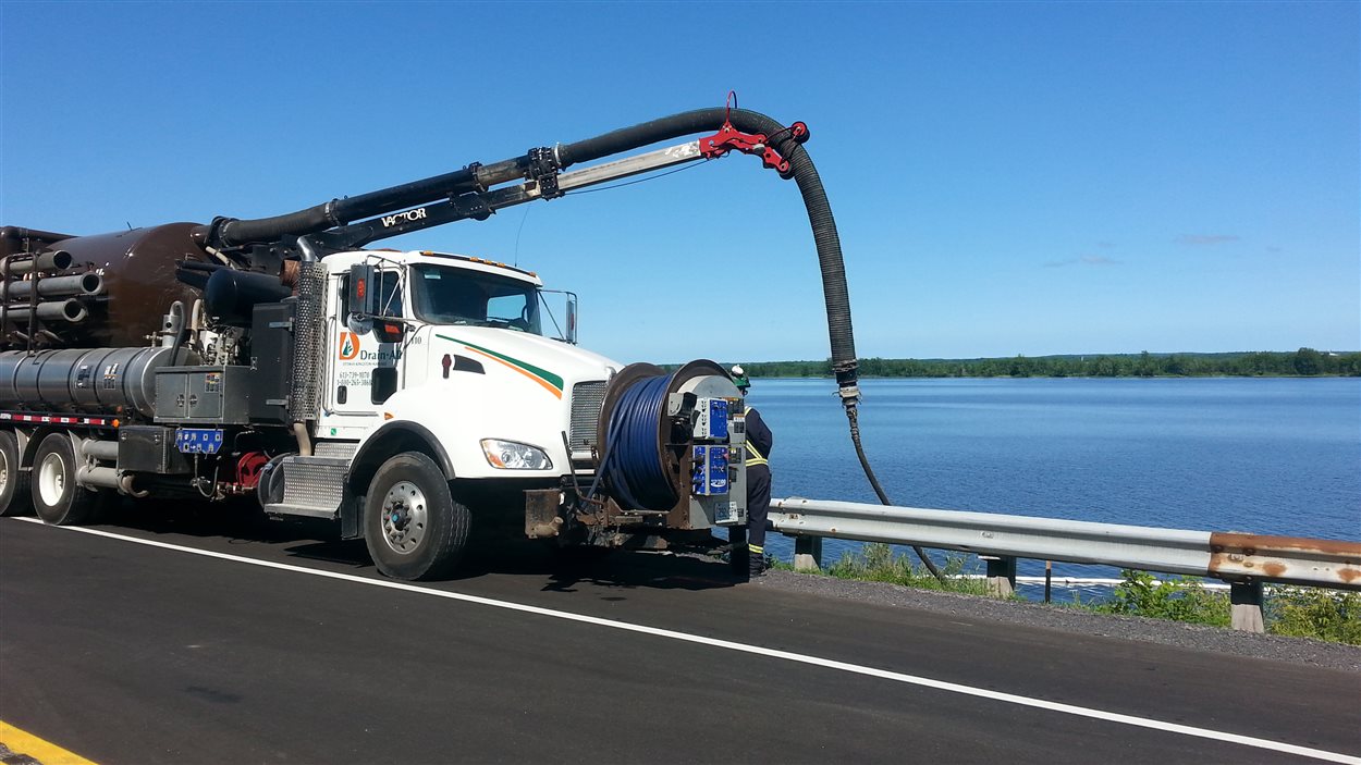 Un camion stationné sur la route 174 récupère le diesel déversé dans la rivière des Outaouais
