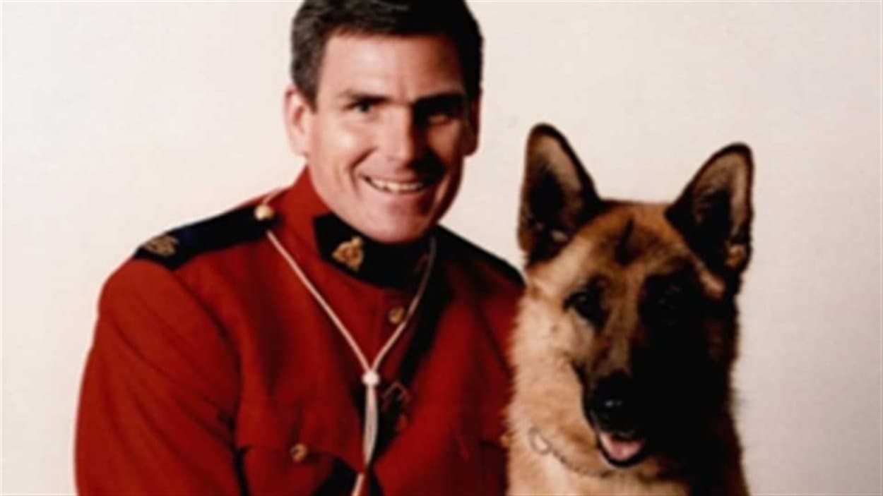 Le caporal et maître-chien Ken Barker, de la Gendarmerie royale du Canada, pose avec un chien.